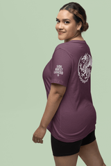 Woman wearing a purple ADHD gamer t-shirt with a side quest legend and dragon graphic on the back.