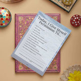 A printable permission list for self-care laid over an ornate book, promoting mental wellness and personal growth.