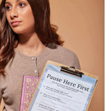 A woman holding a clipboard with mental wellness prompts from the Reset Companion Kit eBook.