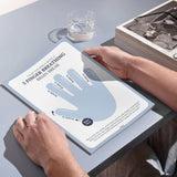 Person holding a '5 Finger Breathing' handout with calming instructions for mental wellness.