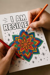 Hands coloring an affirmation page with the text 'I AM RESILIENT' and vibrant floral design for self-care.