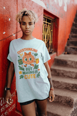 Person wearing a t-shirt with a cartoon character and text, standing against a red wall.