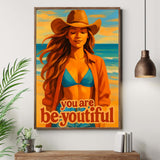 Framed artwork with a woman in a hat and jacket, text 'you are be-youtiful', on a wall above a wooden cabinet.