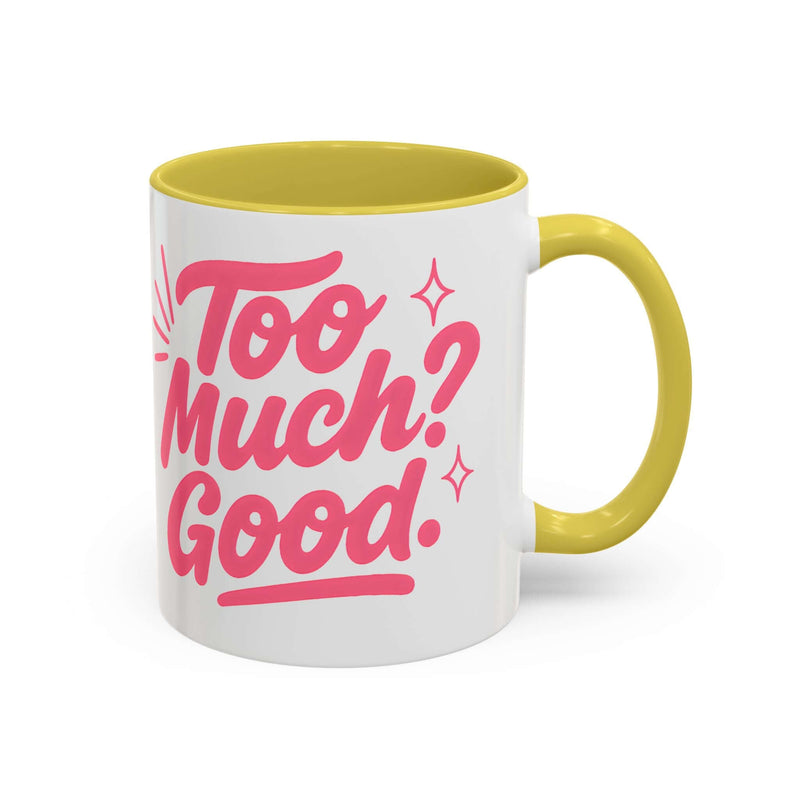 Colorful coffee mug with pink text saying 'Too Much? Good.' and a yellow rim, perfect for home decor and gifts.