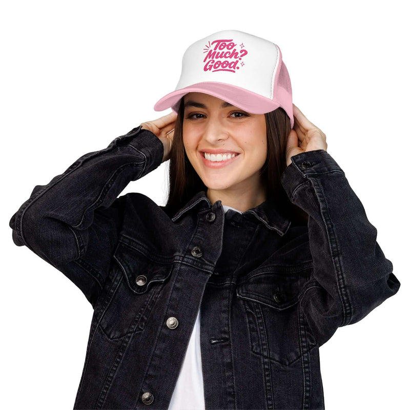 Woman wearing a pink and white Too Much Good trucker hat with a casual black denim jacket.