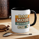 Mug with 'Dad Mode Activated 24/7' text on a wooden surface with coffee beans and a spoon.