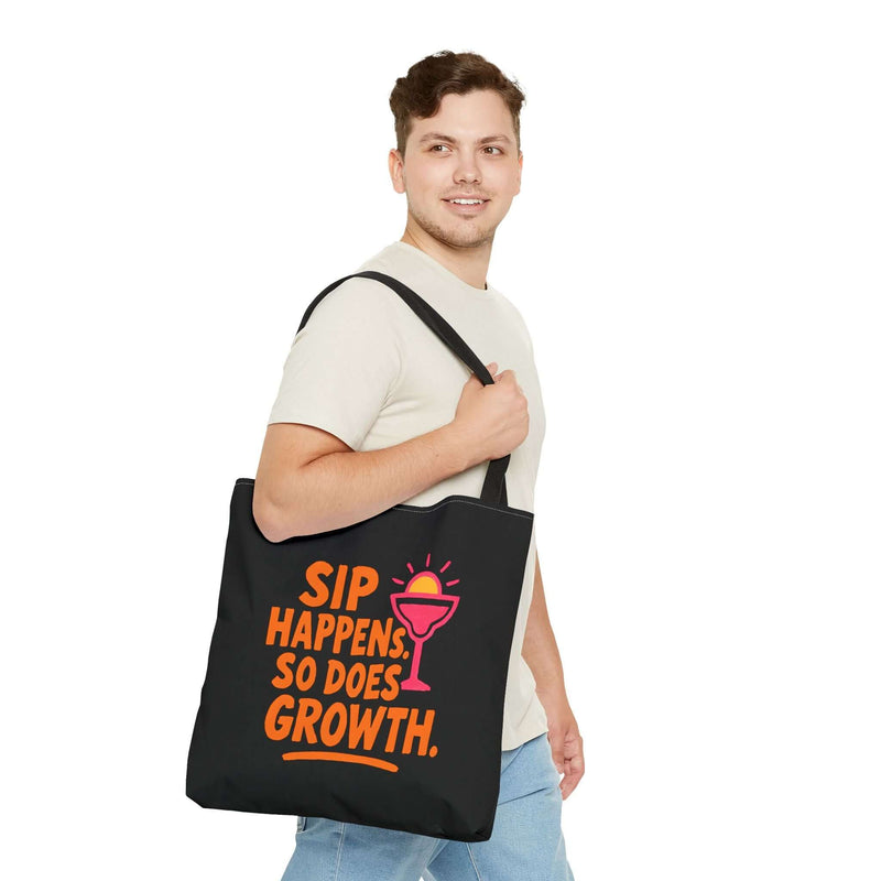 Man carrying black cotton tote bag with colorful 'Sip Happens, So Does Growth' design.