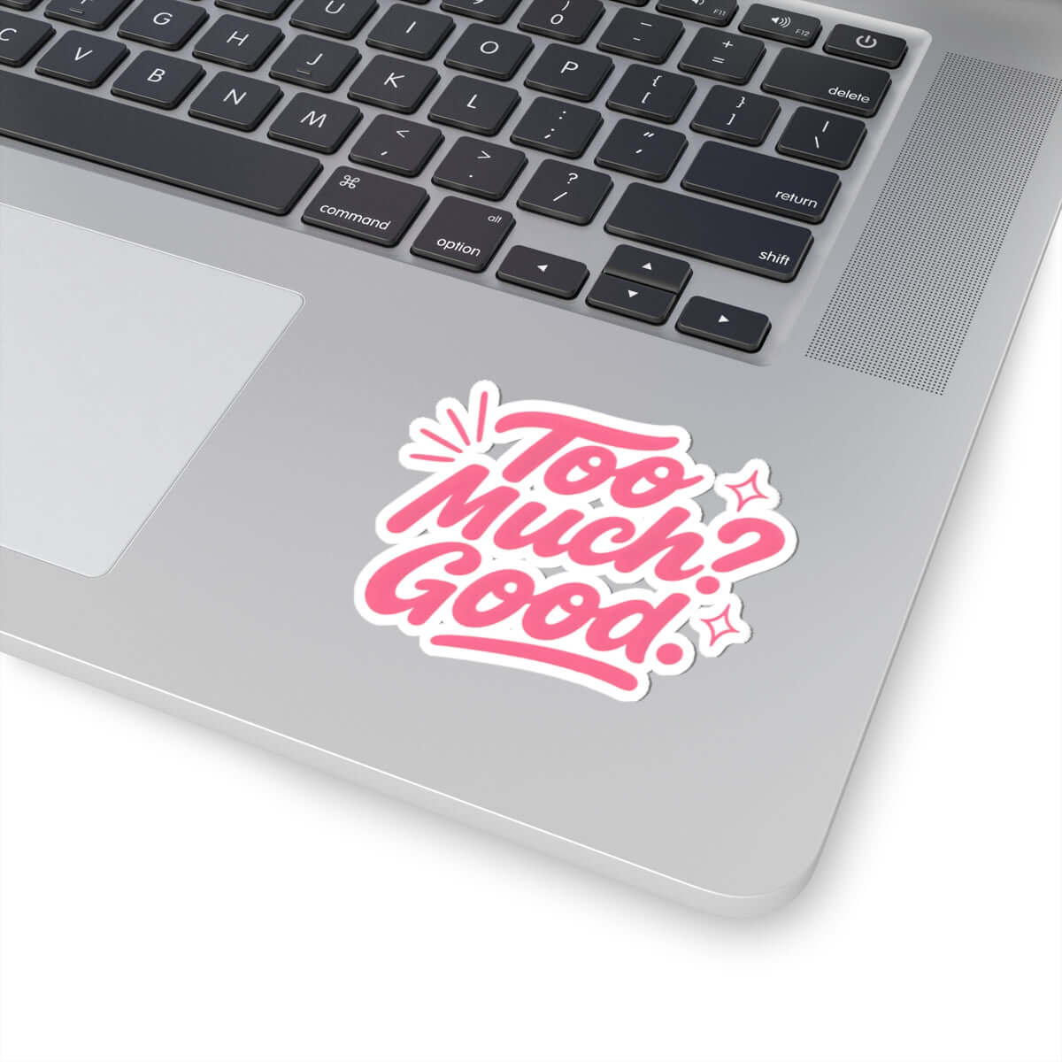 Glossy kiss-cut sticker on a laptop with the text 'Too Much? Good!' in pink and white.