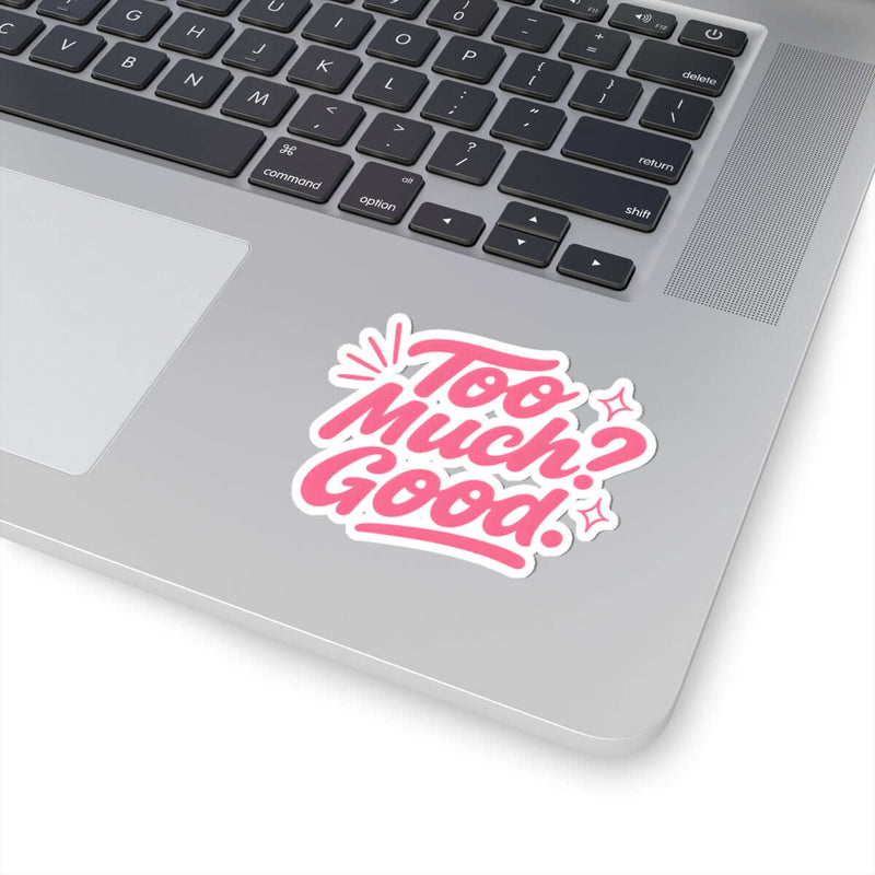 Glossy kiss-cut sticker on a laptop with the text 'Too Much? Good!' in pink and white.