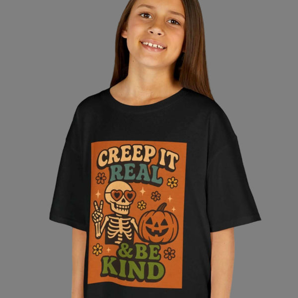 Kids Halloween tee featuring skeleton and pumpkin design with text 'Creep It Real & Be Kind', perfect for festive celebrations.
