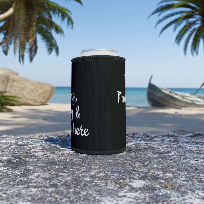 Black stubby cooler displaying fun text, on beach with palm trees and ocean in background, perfect for outdoor drinks.