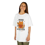 Child wearing a white t-shirt with cartoon cat and 'YOU MATTER' message, promoting positivity and self-love.