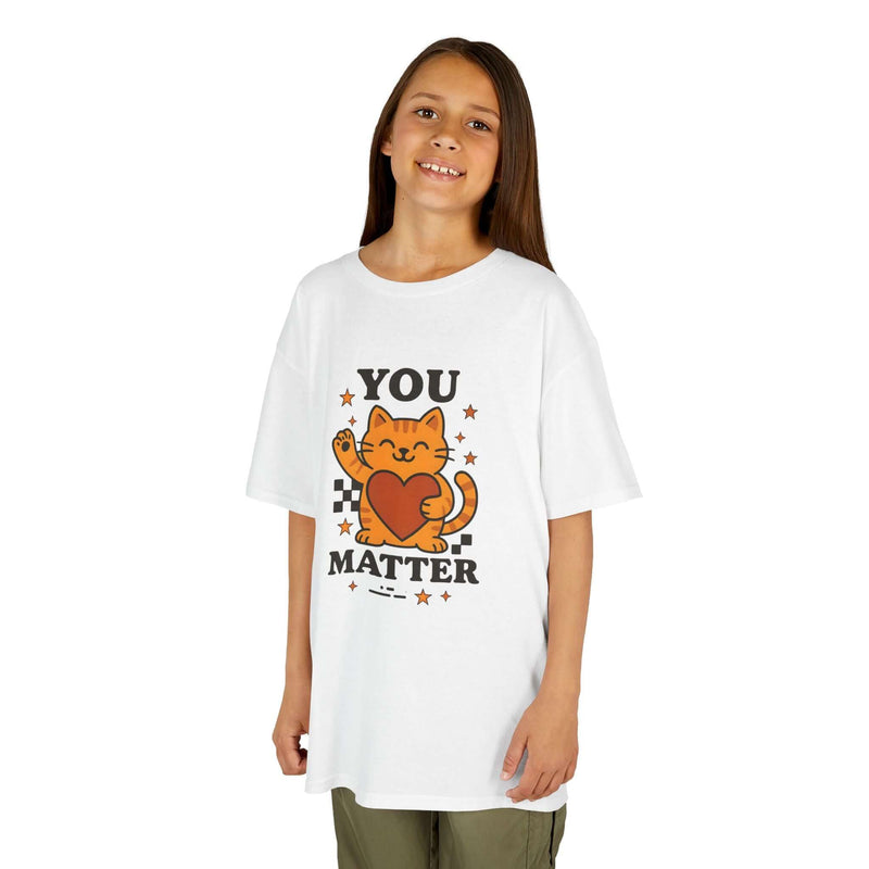 Child wearing a white t-shirt with cartoon cat and 'YOU MATTER' message, promoting positivity and self-love.