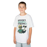 Boy wearing a spooky smart and strong kids tee, featuring a playful skeleton design perfect for Halloween.