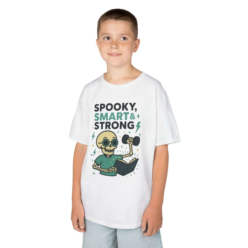 Boy wearing a spooky smart and strong kids tee, featuring a playful skeleton design perfect for Halloween.