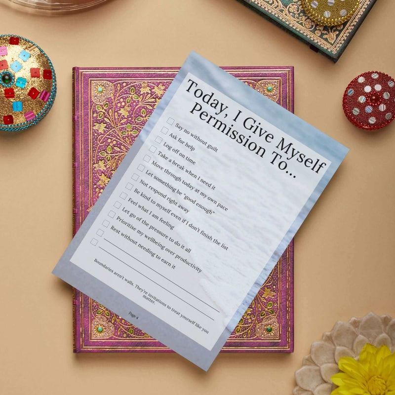 A printable permission list for self-care laid over an ornate book, promoting mental wellness and personal growth.