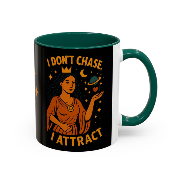Mug with a design of a woman holding planets and stars with text 'I Don't Chase, I Attract' on a black background.