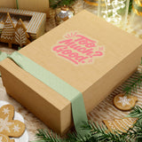 Gift box with playful 'Too Much? Good!' design, adorned with a green ribbon and surrounded by festive decorations.