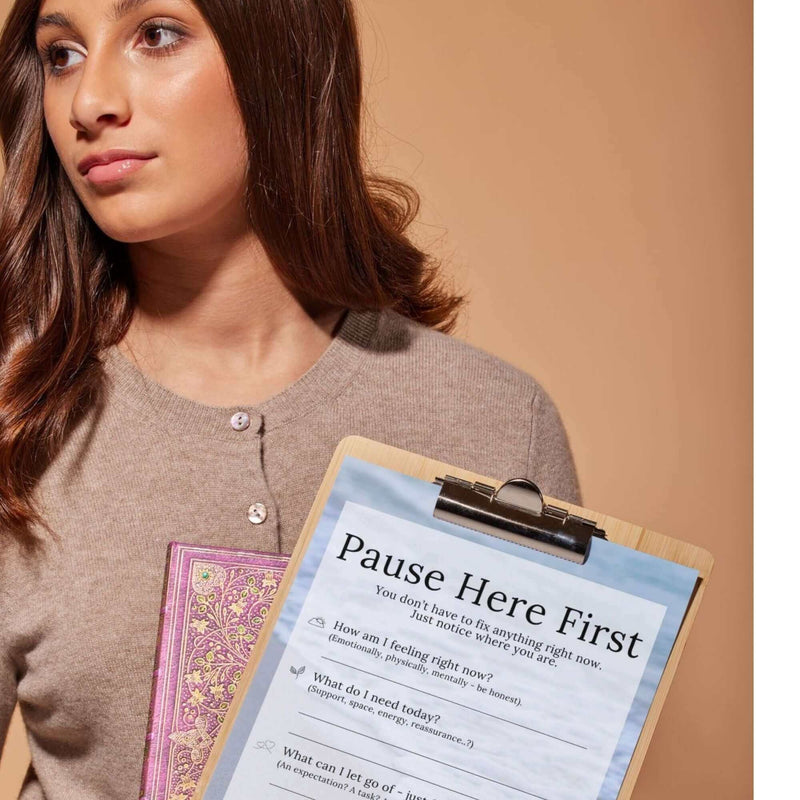 A woman holding a clipboard with mental wellness prompts from the Reset Companion Kit eBook.