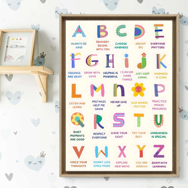 Colorful alphabet poster with moral quotes in a wooden frame on a wall with heart patterns.