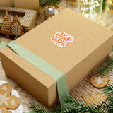 Gift box featuring 'Sip Happens' sticker, surrounded by holiday decorations and greenery for joyful vibes.