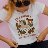Person wearing a white t-shirt with a unicorn graphic and text on a pink background