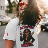 Woman wearing a t-shirt with a graphic and text, standing outdoors.