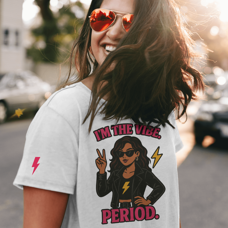 Woman wearing a t-shirt with a graphic and text, standing outdoors.