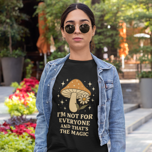 Person wearing a black t-shirt with a mushroom graphic and text, standing outdoors.