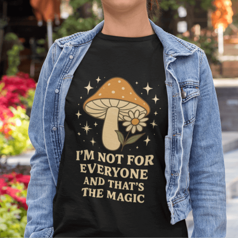 Person wearing a black t-shirt with a mushroom graphic and text, standing outdoors.