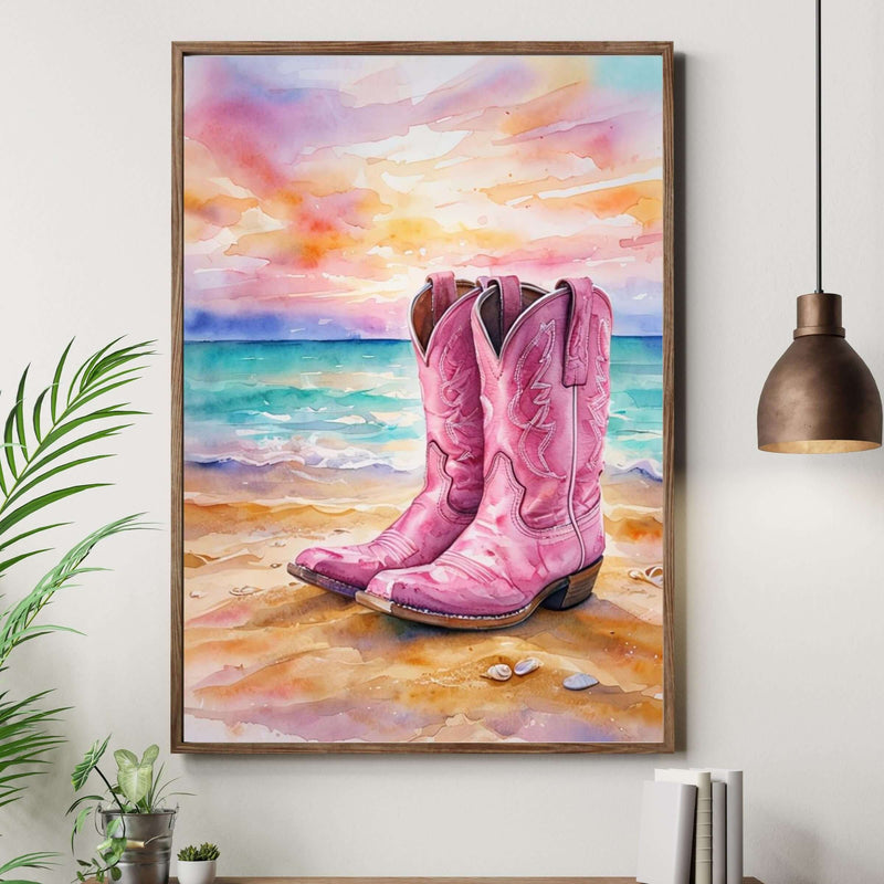Framed painting of pink cowboy boots on a beach with a wooden cabinet and plant in the foreground.