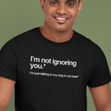 Man wearing a black t-shirt with humorous text on a green background