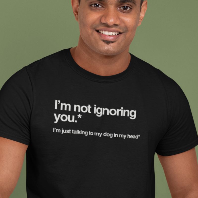 Man wearing a black t-shirt with humorous text on a green background