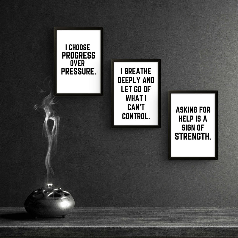 Three motivational wall art prints with empowering quotes for men in a stylish black frame setting.